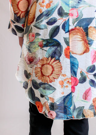 Adore Clothing Floral Print Crepe Tunic Blouse in Cream Multi hem view - Fashion Crossroads Inc.